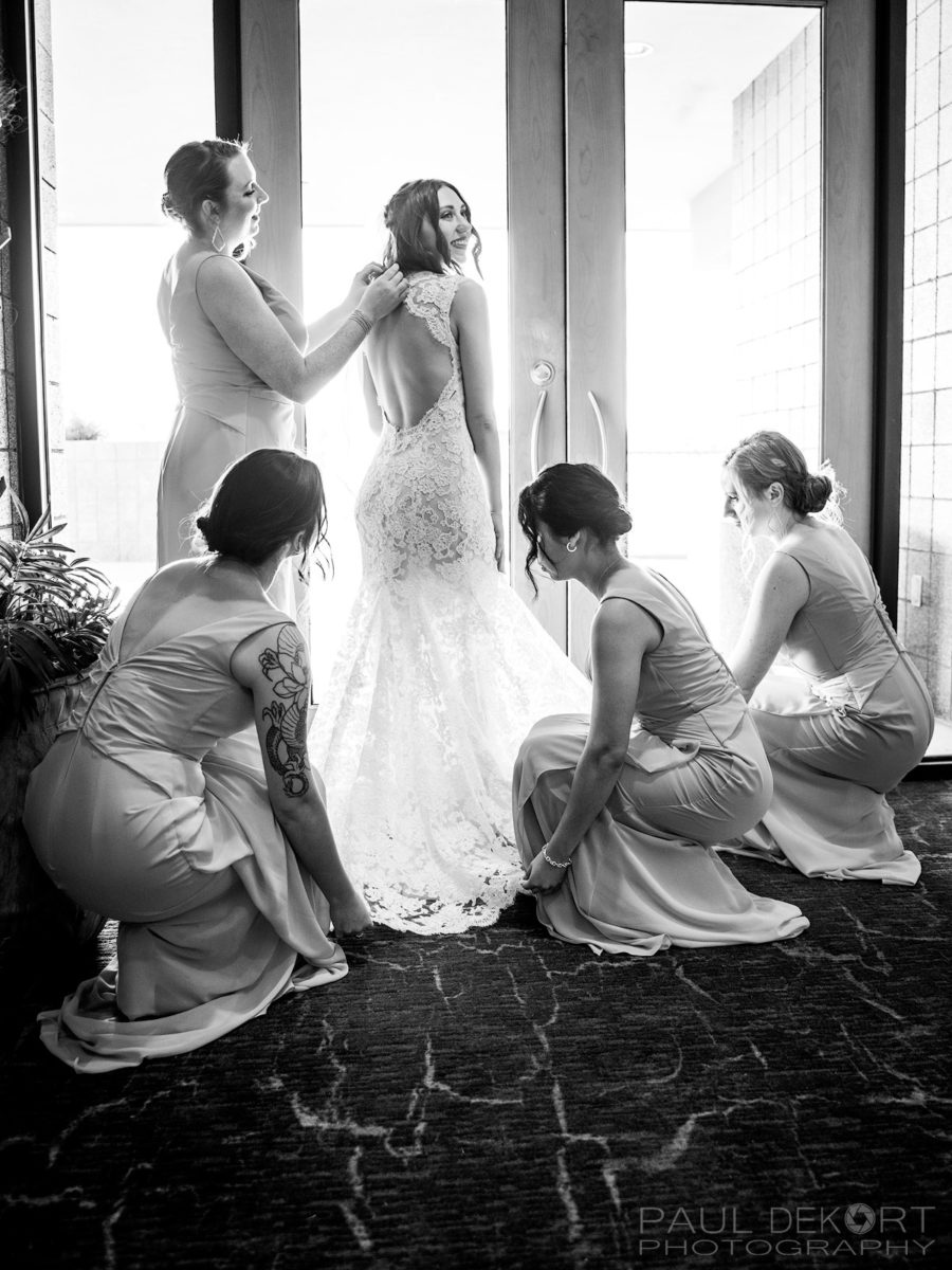 Bridesmaids adjusting Bride's Dress before ceremony BW